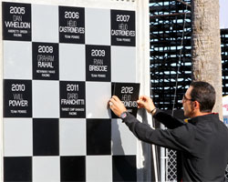 Helio Castroneves hangs his 2012 champion plaque.